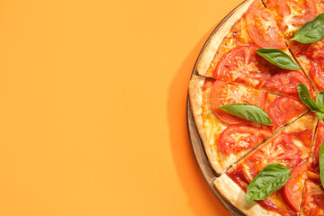 Wooden board with tasty pizza on orange background