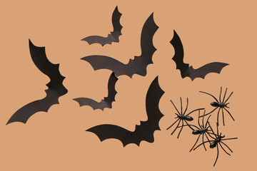 Paper bats and spiders for Halloween party on beige background