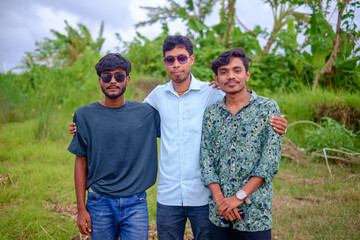 Portrait of south asian young boys standing in an outdoor park wearing sunglasses on their eyes 