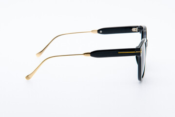Fashion sunglasses black and gold frames on white background.