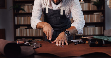 Tailor cobbler hold different rolls natural brown leather, working with textile in workshop. Concept banner Industrial professional craftsman master