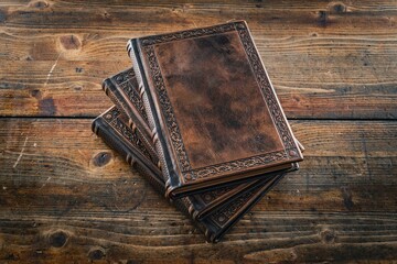 Three aged brown leather journals lay down to old brown table