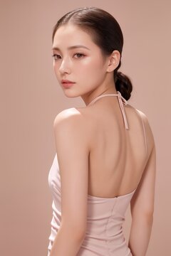 Portrait of beautiful Japanese women with slicked back hair,  wearing backless halter gown in blush pink