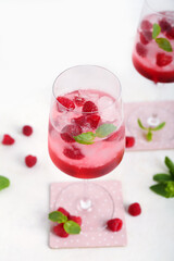 Glasses of fresh raspberry mojito on white background