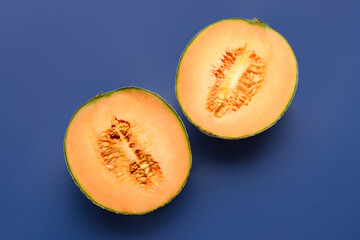 Halves of sweet melon on blue background
