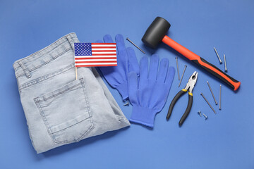Different tools, USA flag, jeans and gloves on blue background. Labor Day celebration