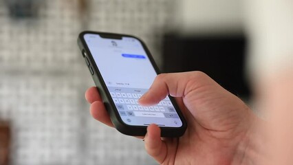 Close-Up: young adult man using cell phone to write messages. Hand hold mobile phone. - Powered by Adobe