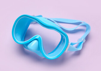 Blue swimming mask on purple , closeup