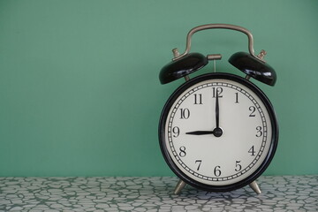 alarm clock on green background - 651463350