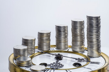 stack of coins and old clock