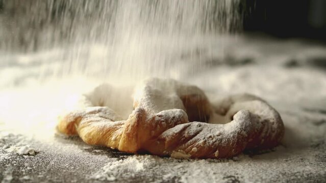 Flour falling slow motion on bread for homemade bakery.
