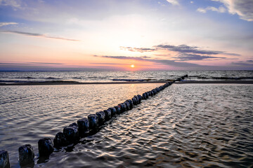 Obraz premium Sunset on the Baltic Sea in Poland. Landscape in the evening with setting sun by the sea.