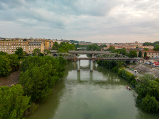 Fototapeta na wymiar Vista aerea del gazometro a Roma. Il fiume Teveree il ponte di ferro