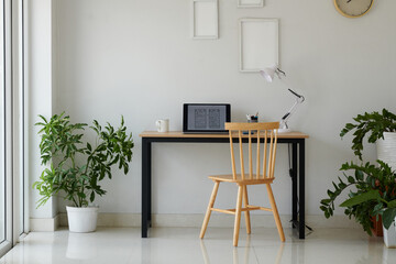 Laptop with mobile app wireframe on screen on desk in home office