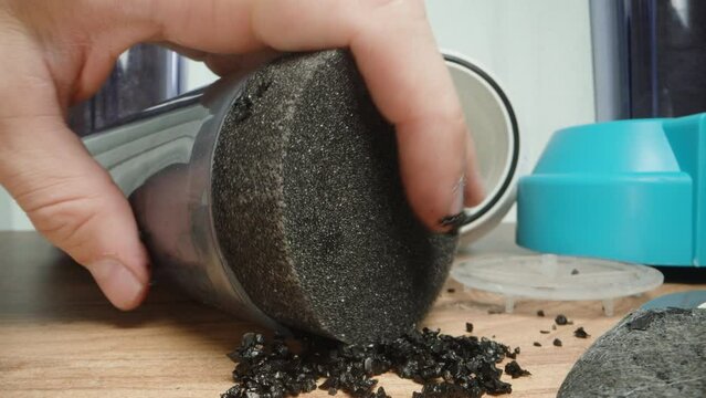 A man assembles a carbon water filter. Close-up.