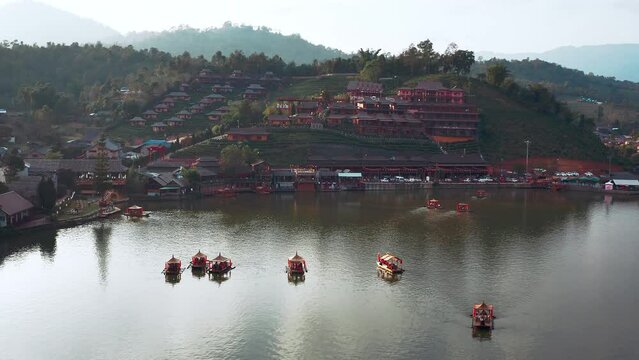 Asian chinese boats with mist on the lake and view on the architecture buildings in Thailand. Aerial shot forward 