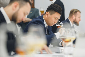 Professional sommelier sniffing unknown whiskey during blind tasting. Sommelier exam to study different wine and whiskey.