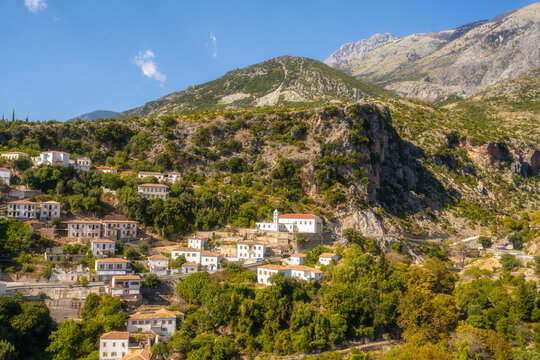 View of white houses with yellow shutters, moutains and sea. Vuno, Albania.