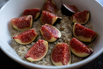 Autumn oatmeal porridge with figs in a bowl on black background. top view. diet breakfast. healthy food
