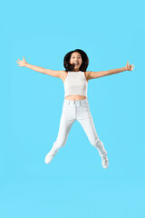 Jumping Asian woman on blue background