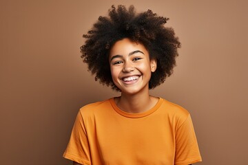 Obraz na płótnie Canvas portrait beautiful afro american teenager girl dressed in t-shirt and smiling, light background