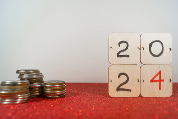 Christmas spending. inscription 2024 on wooden cards and pyramids of coins