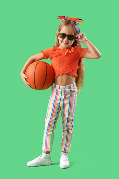 Cute little girl with ball on green background