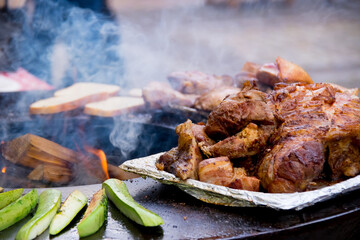 Juicy delicious grilled meat, with flame and smoke. Food and kitchen concept.