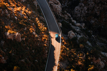 Aerial view of a car traveling across a scenic highway. Roadtrip during the autumn season