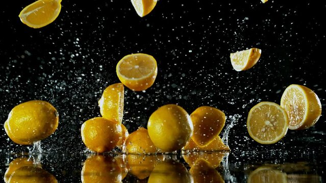 Super Slow Motion of Falling Lemon Slices into Water on Black Background. Filmed on High Speed Cinema Camera, 1000 fps.