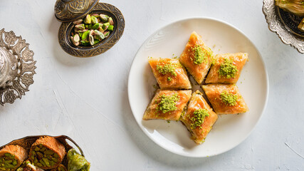 An image taken from above of a plate of Arabic sweets on a white background. Name of the item in Arabic: baklawa