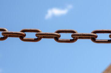 rusty chains, sky background, a symbol of strength and oppression, used in industry in crowbars as...