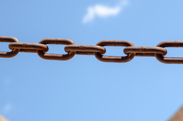 rusty chains, sky background, a symbol of strength and oppression, used in industry in crowbars as...