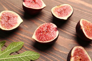Halves of fresh ripe figs on wooden background