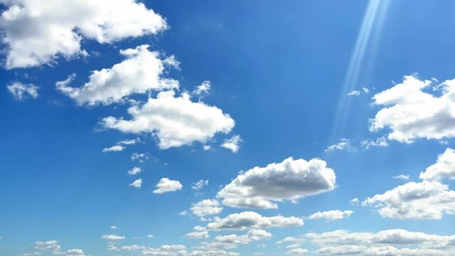 Fluffy clouds float across the blue sky. Beautiful landscape