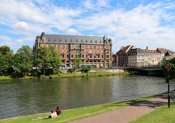young couple sitting on grass along the river on university campus in Strasbourg - France - 651513181
