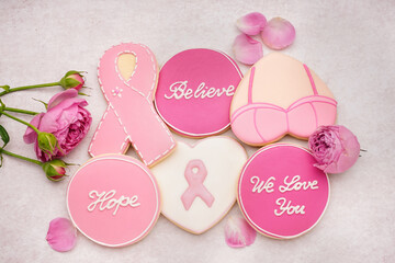 Cookies with pink ribbons and supportive words on grey grunge background. Breast cancer awareness concept - obrazy, fototapety, plakaty