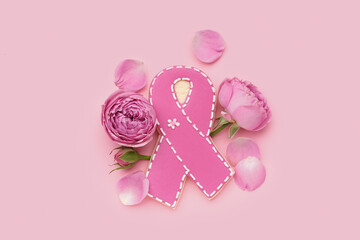 Cookie in shape of ribbon and rose flowers on pink background. Breast cancer awareness concept - obrazy, fototapety, plakaty