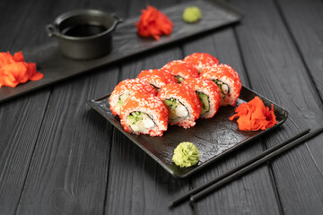Sushi set with caviar, avocado and salmon on black slate plate. Asian cuisine concept.