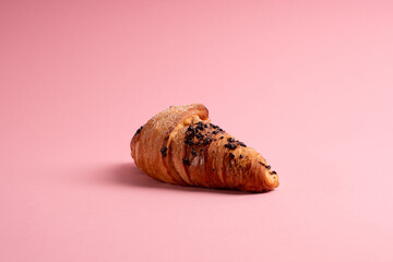 Isolated croissant with chocolate on a pink background. 