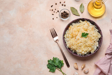 Bowl with delicious sauerkraut and spices on pink background