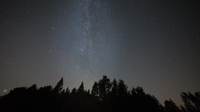 Night sky time lapse with Milky Way and meteor shower and rising moon.