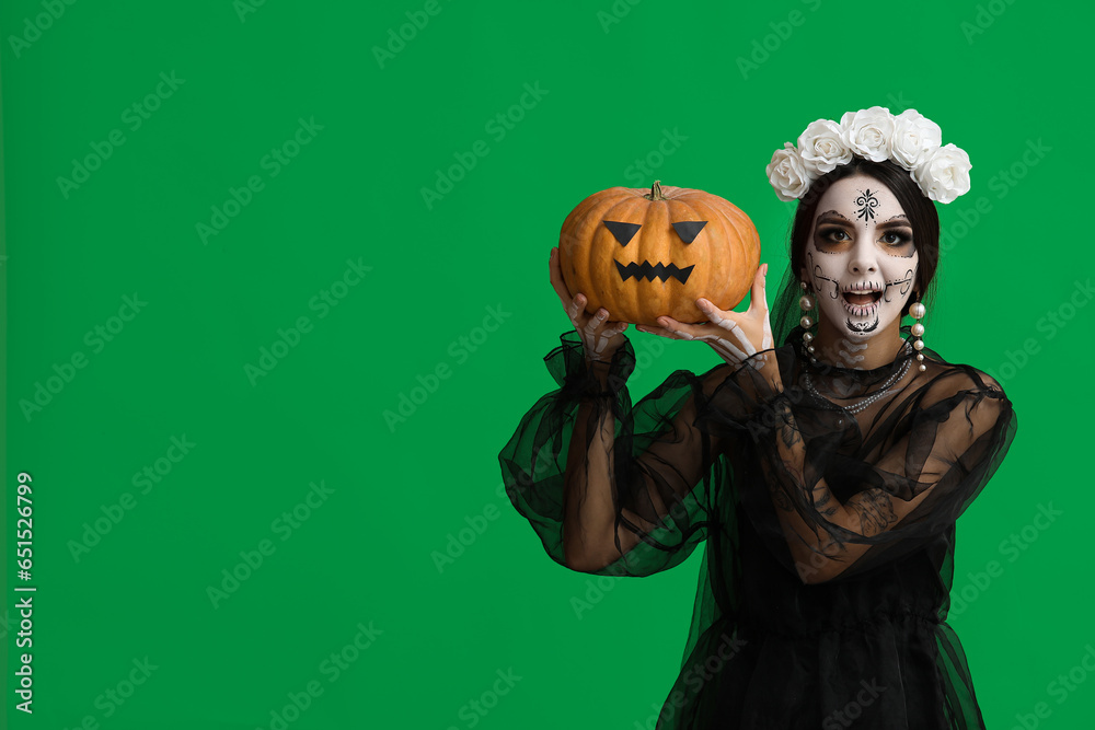 Canvas Prints Beautiful young woman dressed as dead bride for Halloween party with pumpkin on green background