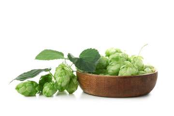 Wooden bowl with fresh green hops and leaves on white background
