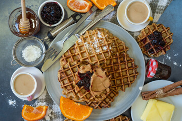 Homemade waffles with blueberry jam and peanut butter.