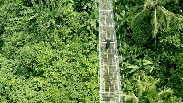 An adventure traveller crosses the 160 meter suspension bridge in Lumondo, Alegria in the Philippine jungle. 