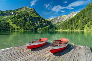 Steg mit Ruderbooten am Vilsaplsee im Tannheimer Tal mit den Allgaeuer Alpen, Tirol Oesterriech