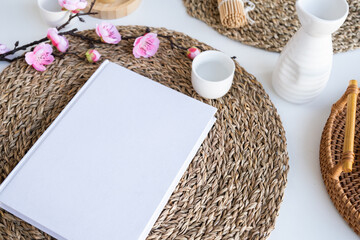 Book mockup design. Blank white book on dining table in asian style with tableware