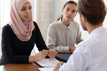 Multicultural businesspeople negotiating in office boardroom. Middle eastern ethnicity female ceo...