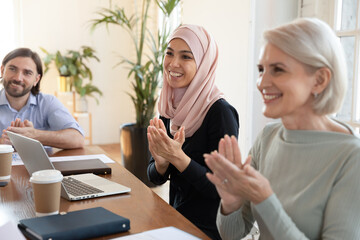 Multicultural businesspeople clap hands finish meeting, different culture and age workers greet coach start seminar, cheering applauding successful employee, reaction after motivational speech concept